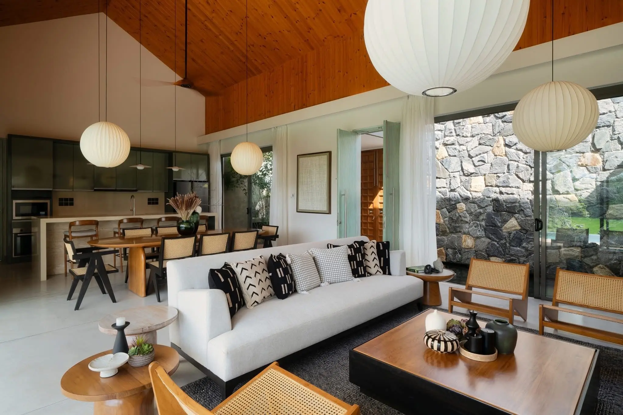 Open-plan living room at Hansa Villa with warm timber interiors opening towards the gardens