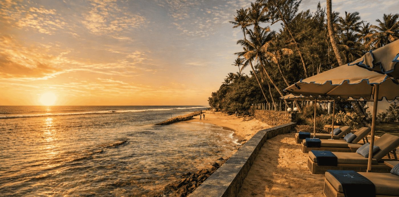 Sun loungers with umbrellas on the sand at IF Villa at golden hour, the ocean alongside