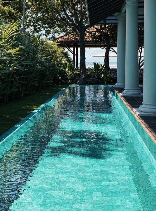 The lap pool at IF Villa running beside the white colonnade toward the sea