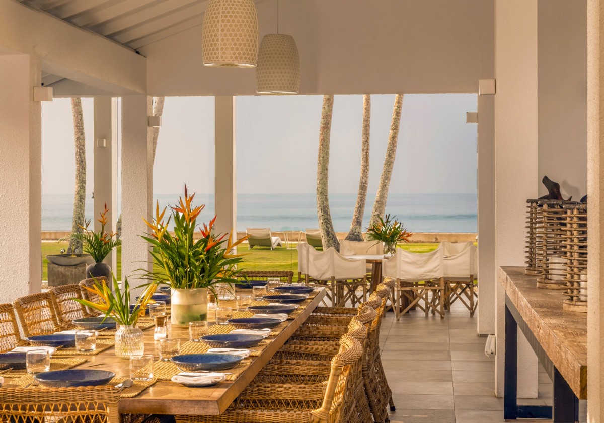 Open-air dining terrace at Ishq Talpe set for dinner, looking out to the ocean