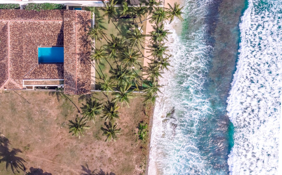 Aerial view of Ishq Talpe's roof, courtyard pool, palm lawn and the surf below