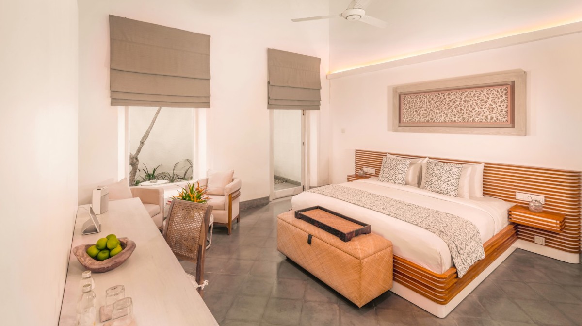 Bedroom 5 at Ishq Talpe — a king bedroom with a writing desk and doors opening to a small garden patio
