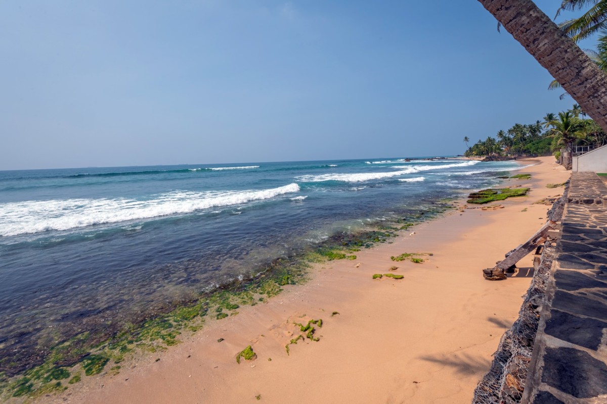 Sandy shoreline and gentle surf along Talpe beach in front of the villa