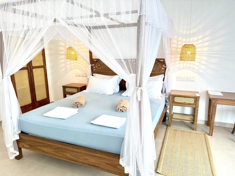 Double room at Lily Mirissa with four-poster bed, mosquito net and woven pendant lamps