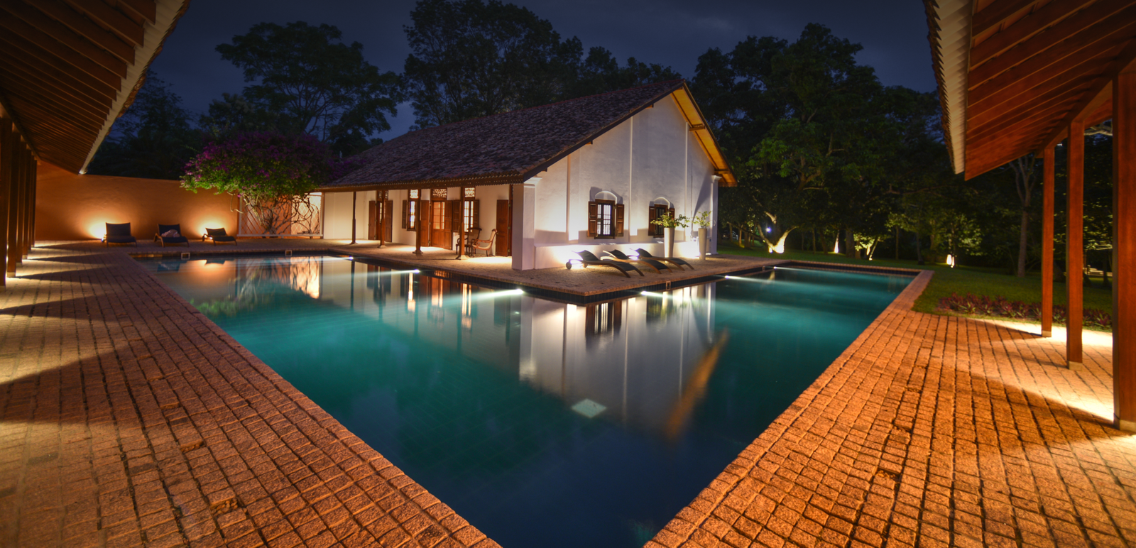 The 20-metre L-shaped swimming pool at Maya Tangalle framed by lawns and garden