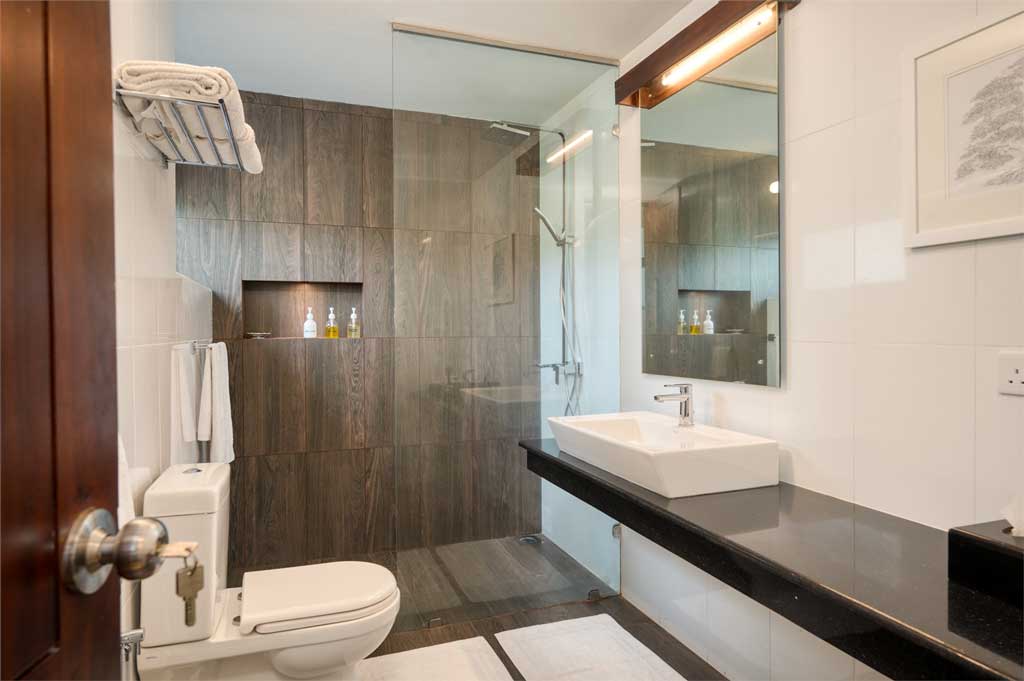 A bathroom at Mirissa Beach Villa finished in stone and timber