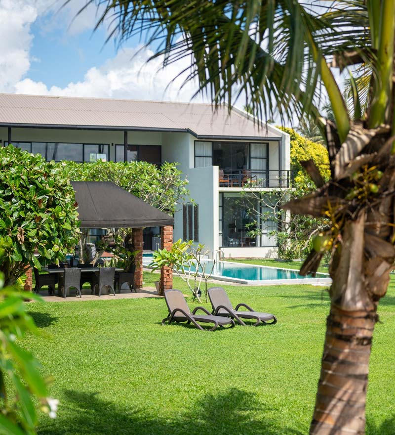 Manicured lawns and sun loungers in the gardens at Mirissa Beach Villa