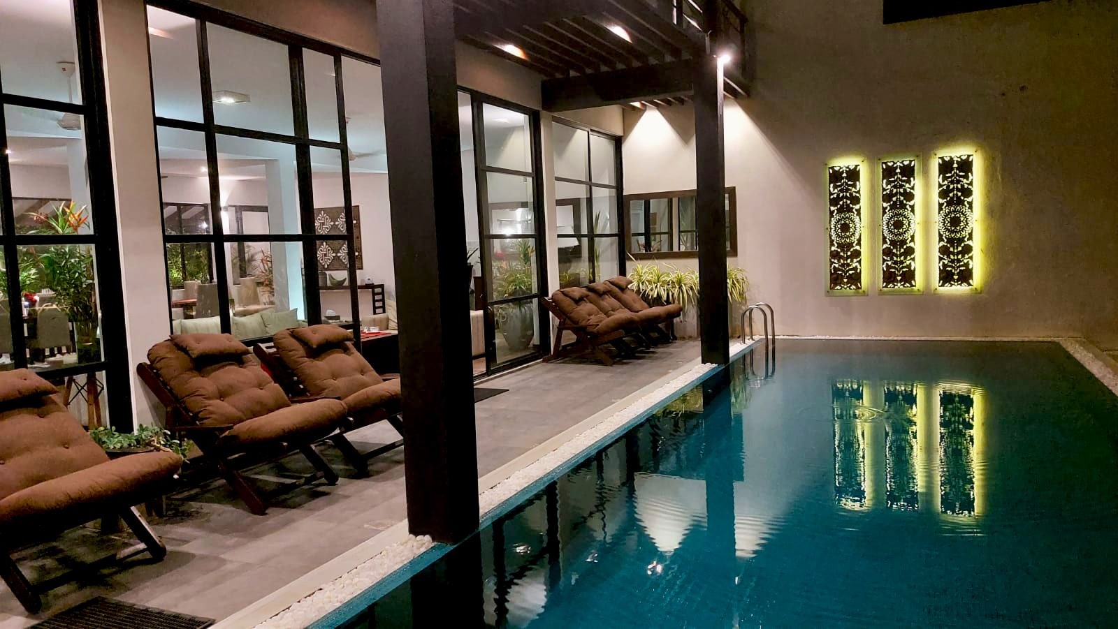 The second pool at Mirissa Beach Villa at dusk with loungers along the water