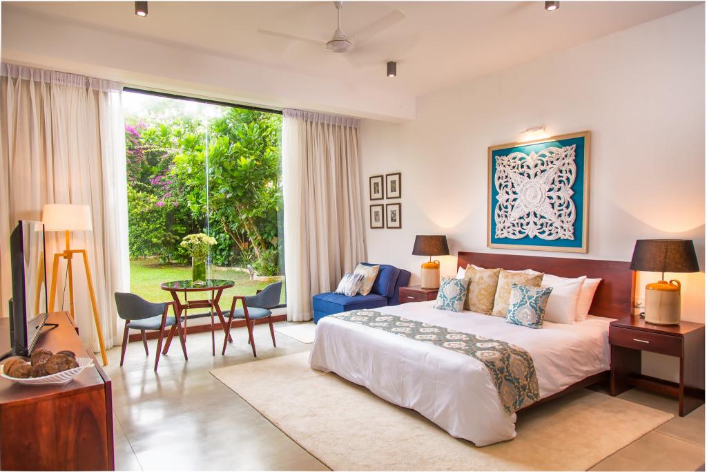 Sea View Room at Mirissa Beach Villa with glass doors opening towards the garden and pool