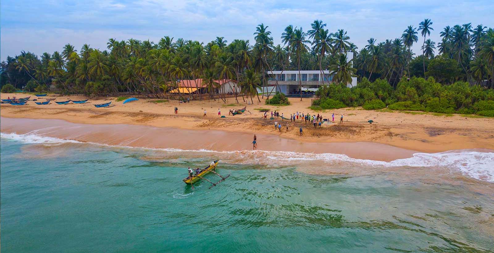 Golden beach at Kahandamodara with a fishing boat in the shallows