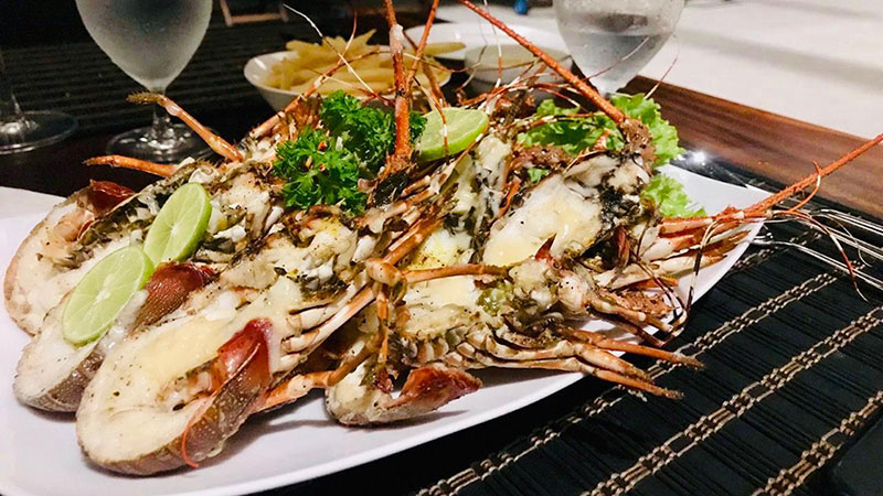 Plated grilled seafood with lime and parsley at the villa restaurant