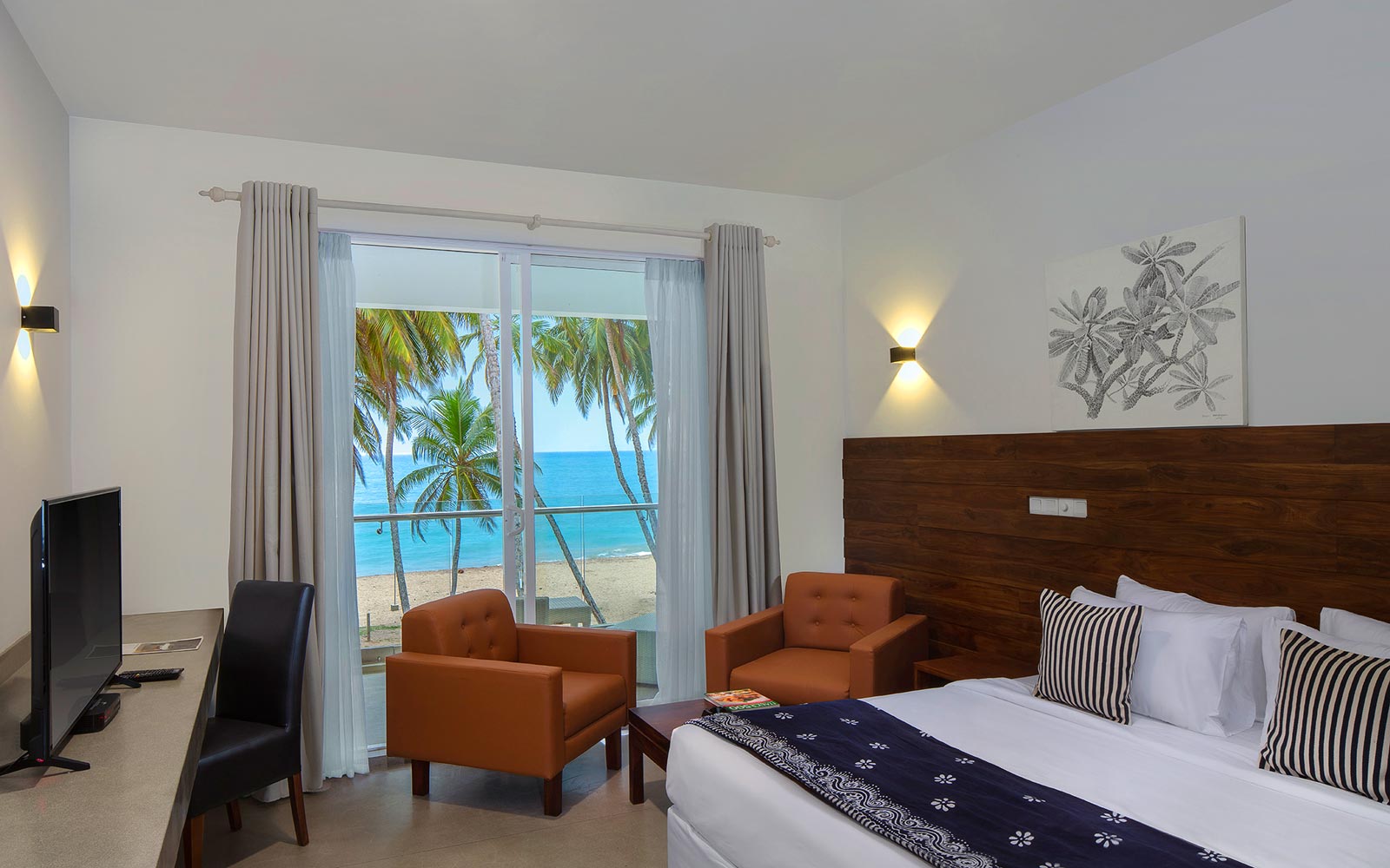 Double Room at Serendivi with armchairs and glass doors opening to the beach and ocean