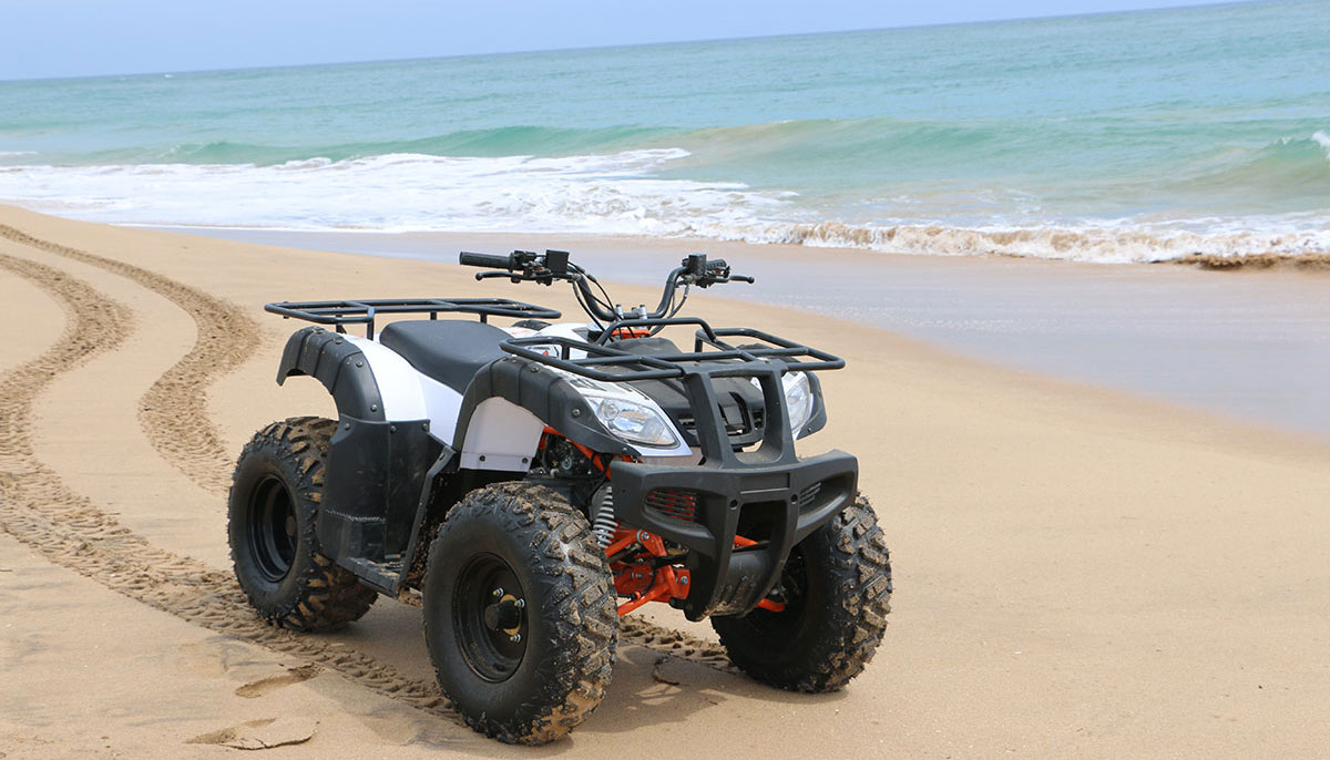 Quad bike parked on the sand at the water's edge