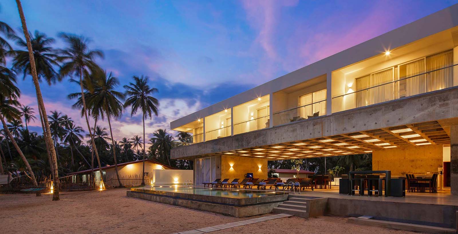 Villa glowing at sunset under a pink and violet sky