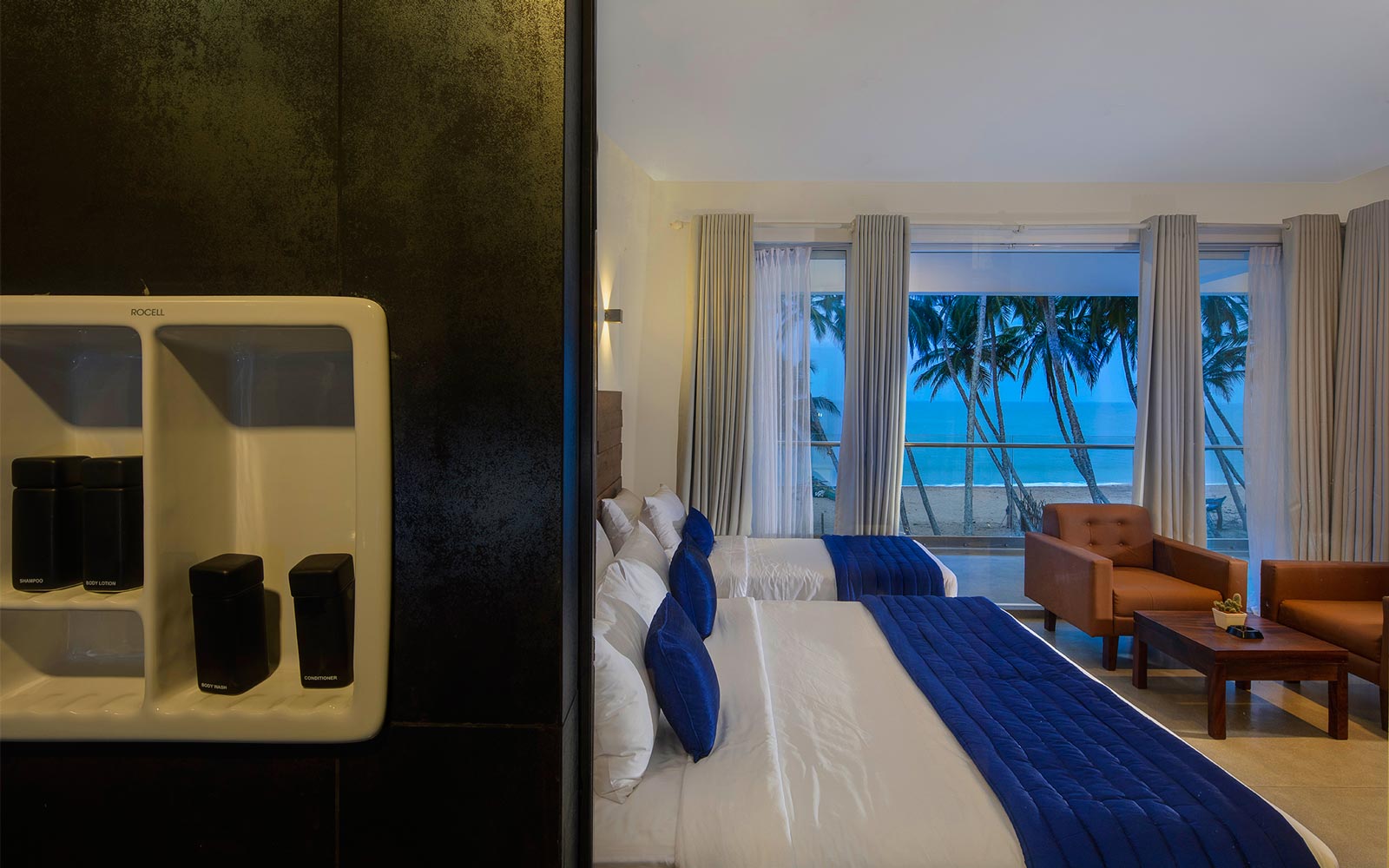 Triple Room at Serendivi with beds dressed in white and blue, facing the ocean