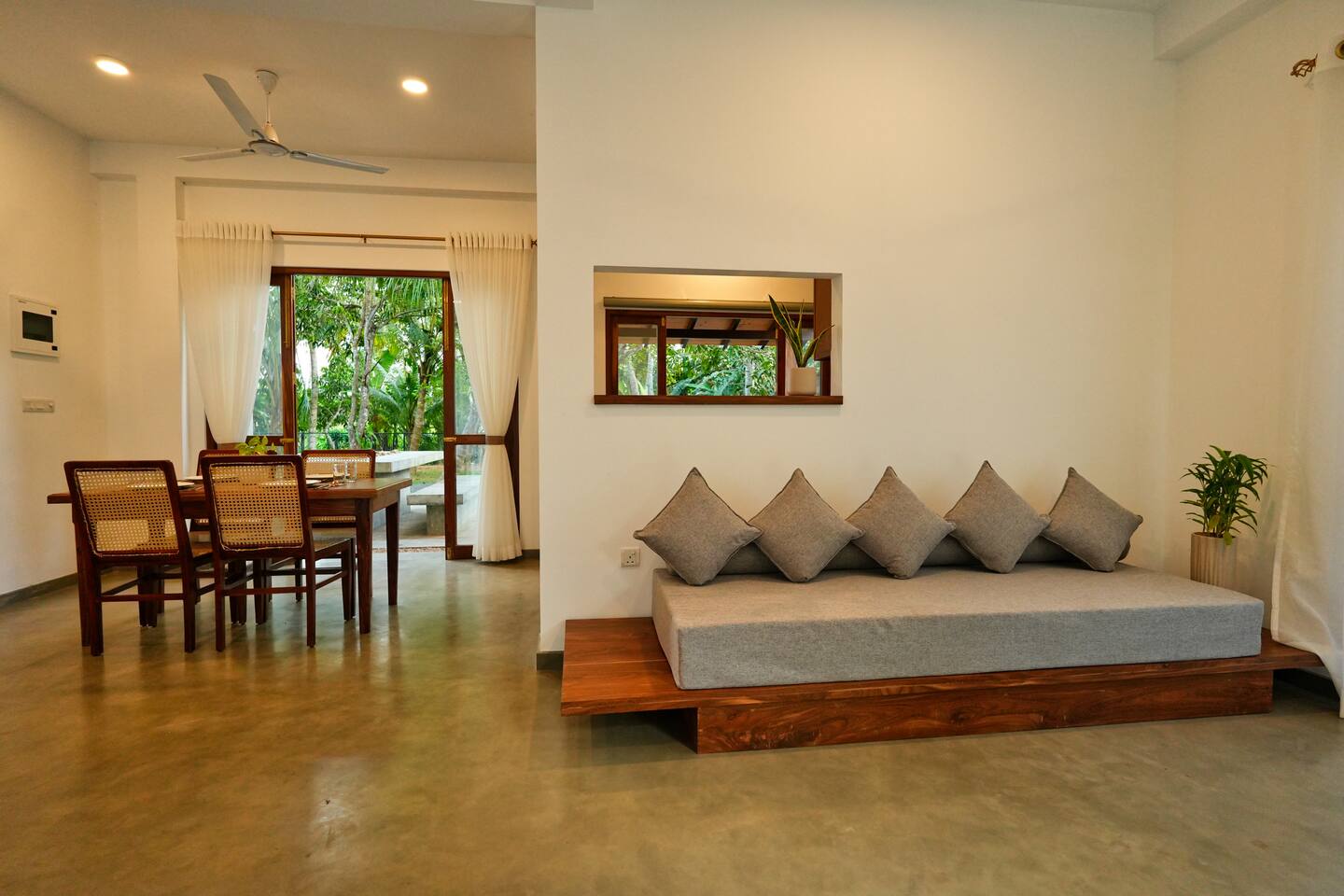 Open-plan living space at Summer Secret with glass doors opening onto the tropical garden