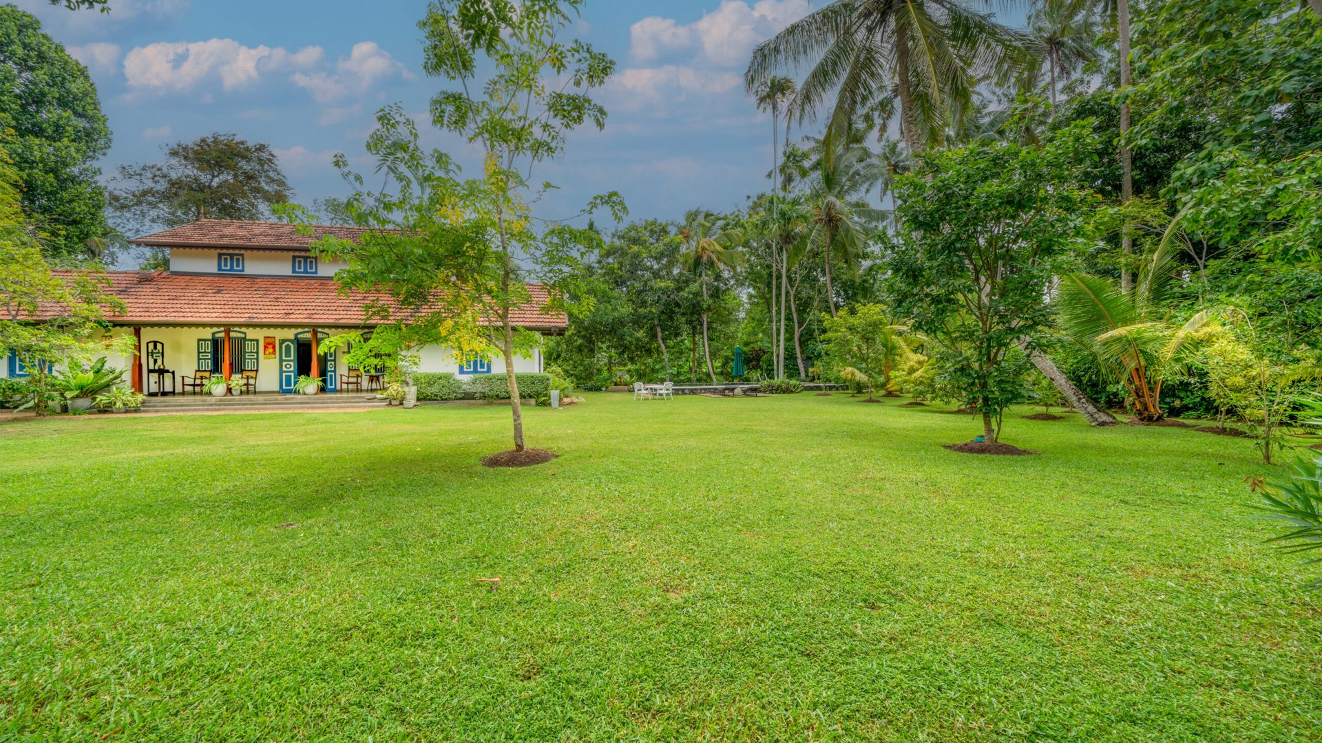 The villa seen across its lawn and gardens