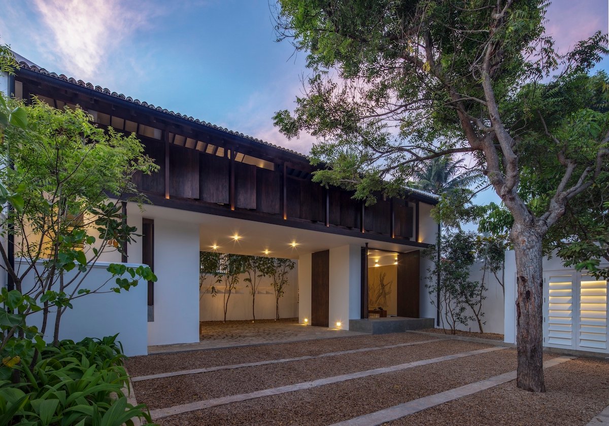 Three Gables Boutique Villa at dusk, its dark timber gables glowing above the entrance court