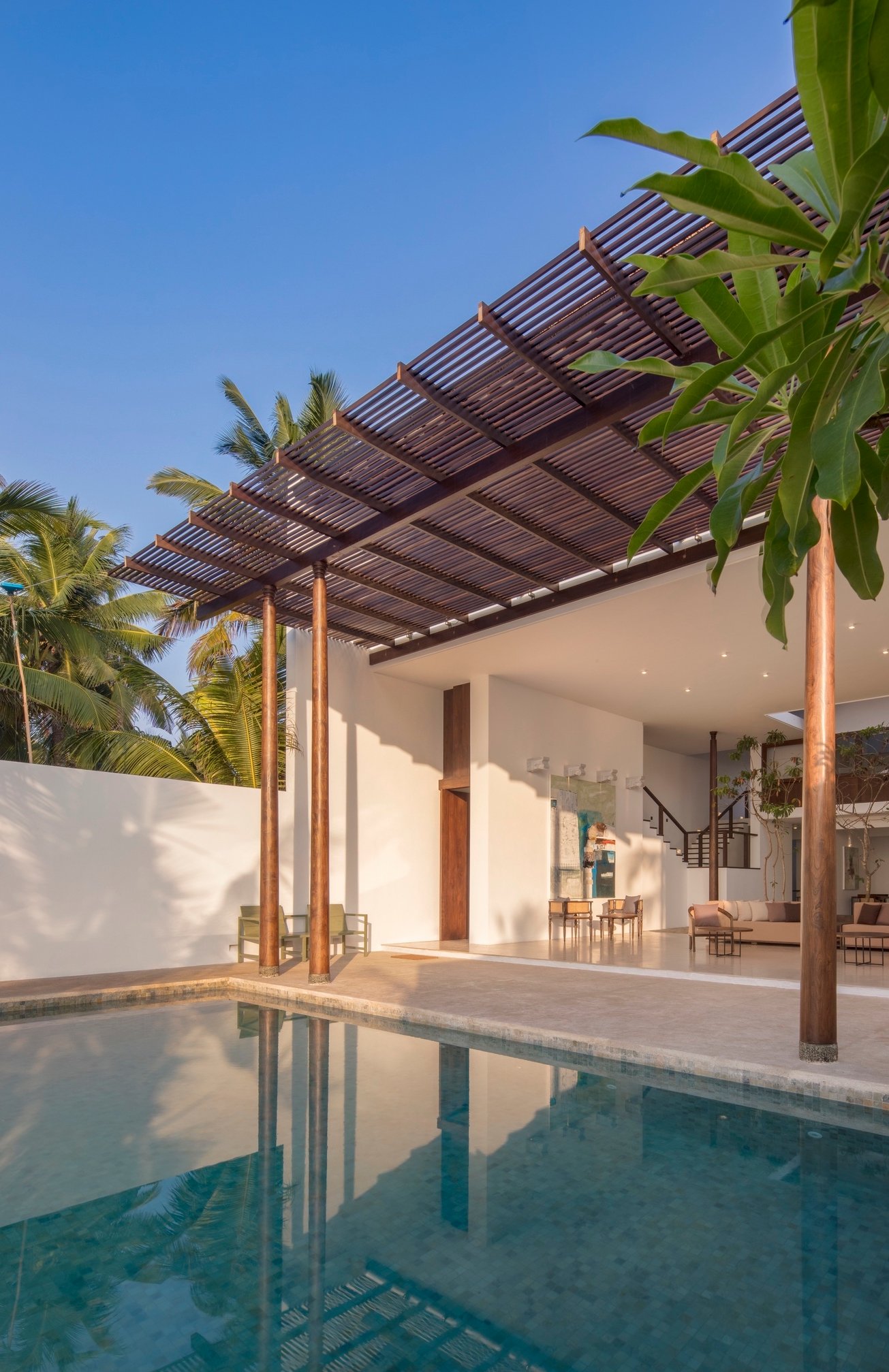 The infinity pool at Three Gables Boutique Villa beneath the timber pergola, reflecting the villa