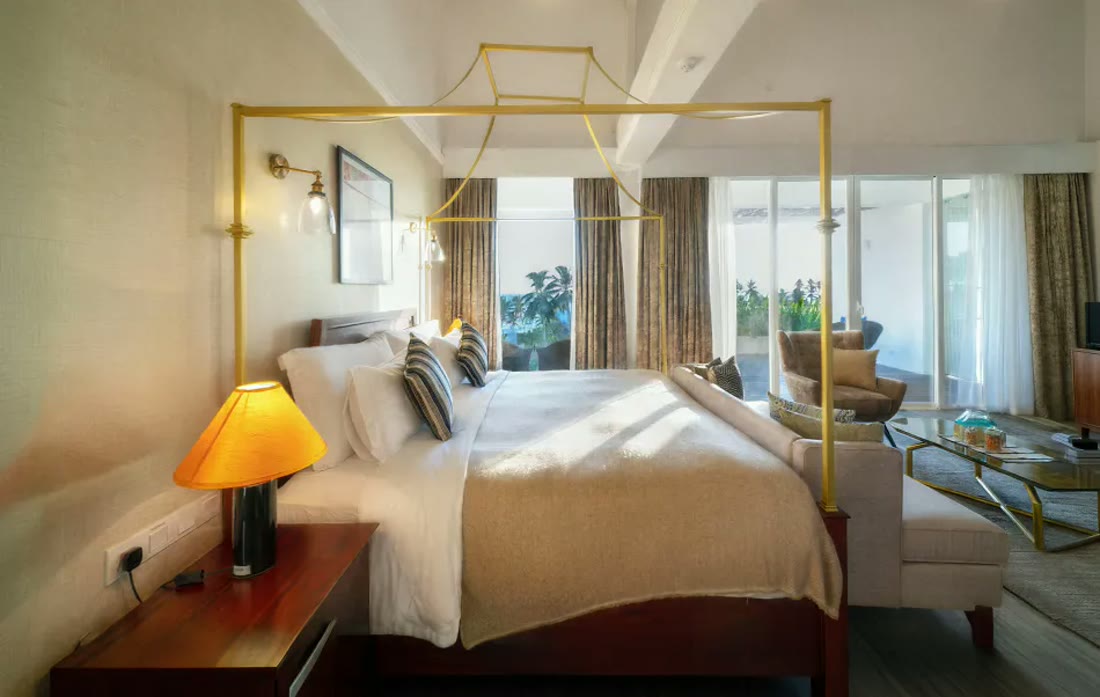 Suite Spice at Triple O Six with a warm-lit four-poster bed and sunlit windows