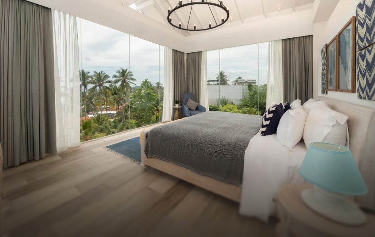 Presidential Suite at Triple O Six with floor-to-ceiling glass looking over palms towards the sea