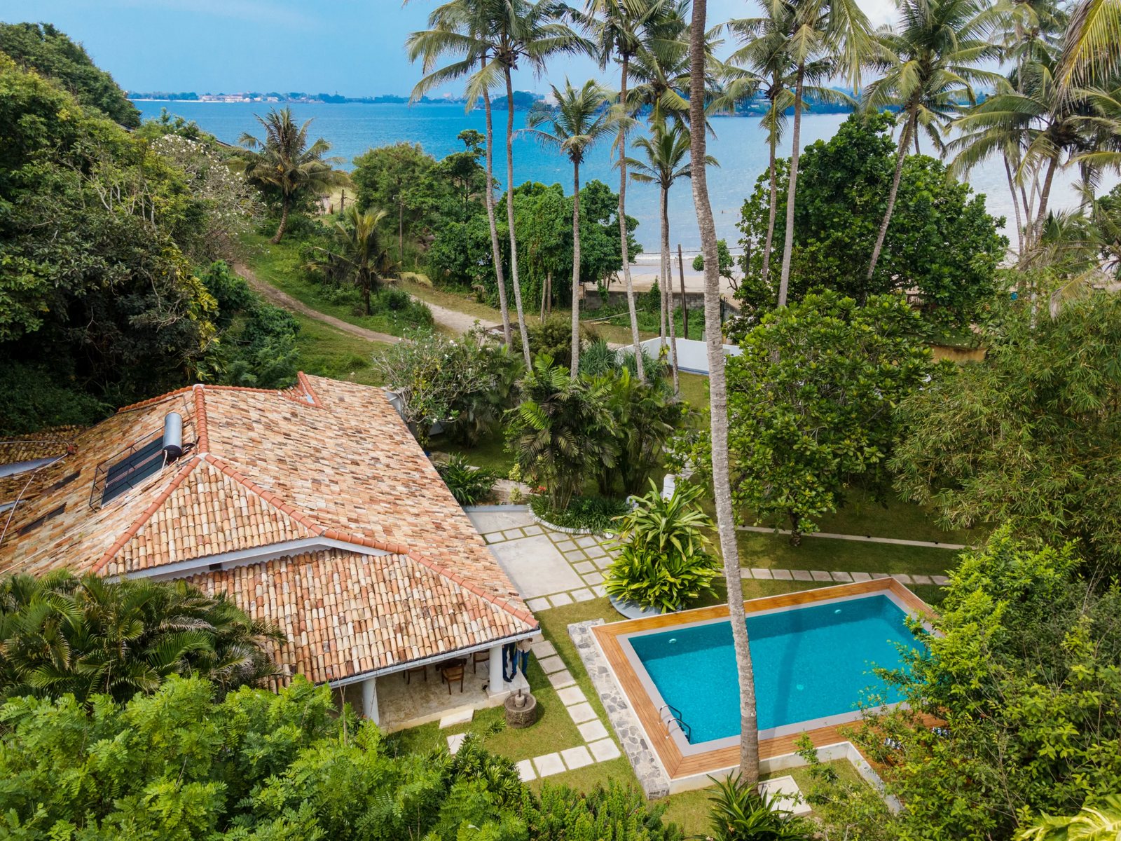 Aerial view of the villa roofs, pool and the bay
